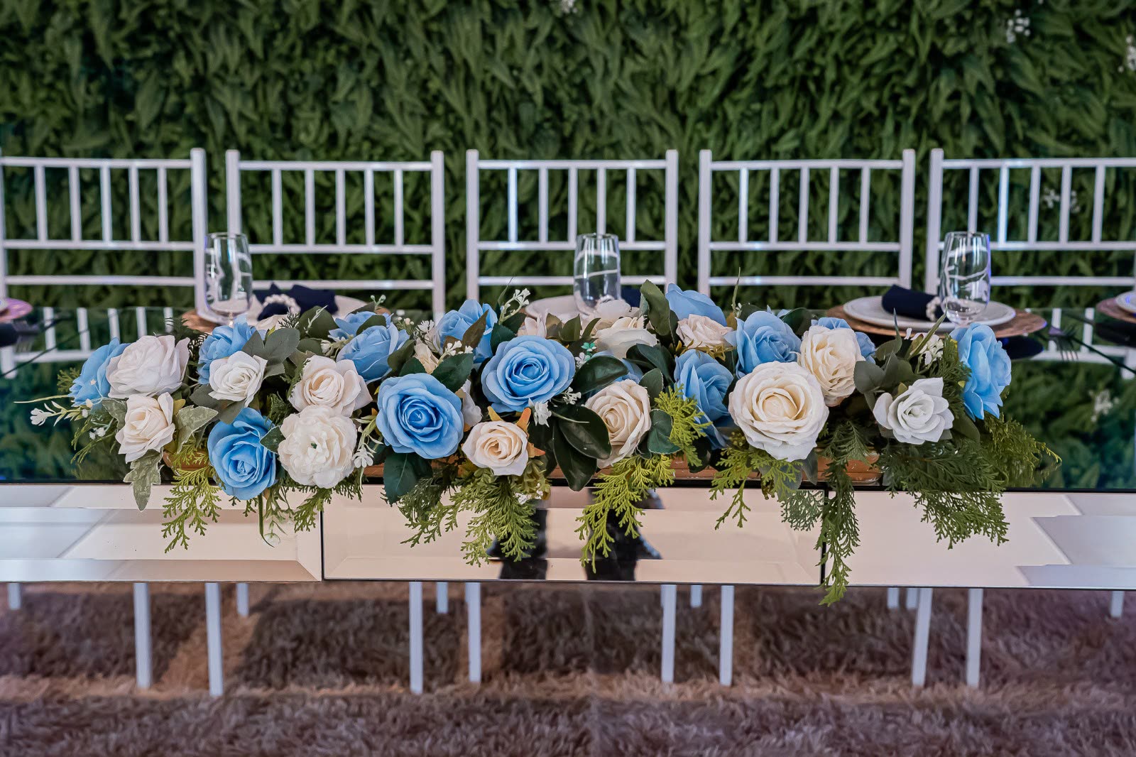 Mesa de recepção posta com louça dourada e cristais