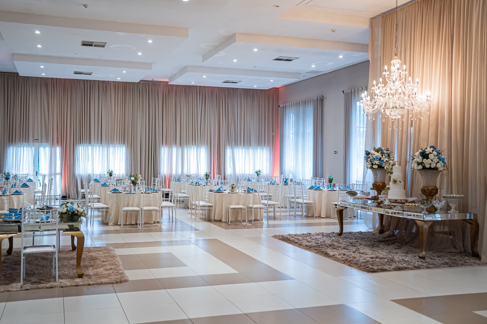 Salão de recepção decorado em branco com lustres